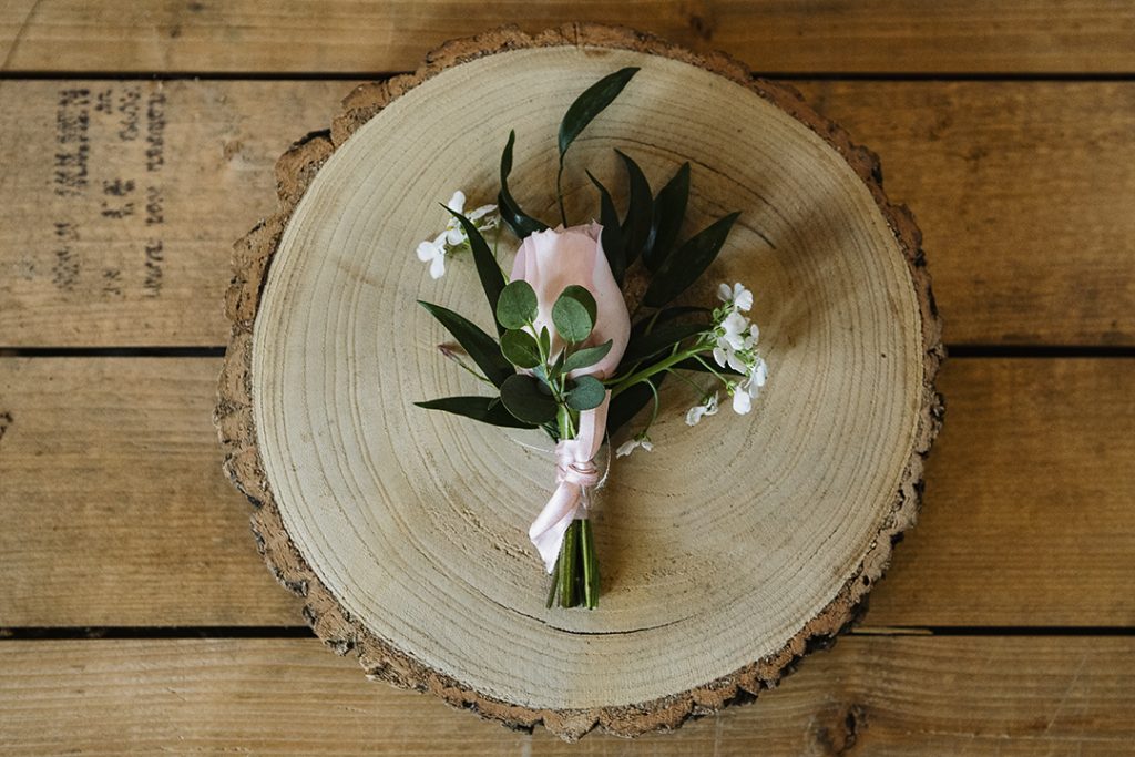 Pretty posy of flowers displayed on s rustic log for a Buckinghamshire flower farm business