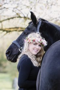Black horse with woman wearing a floral crown