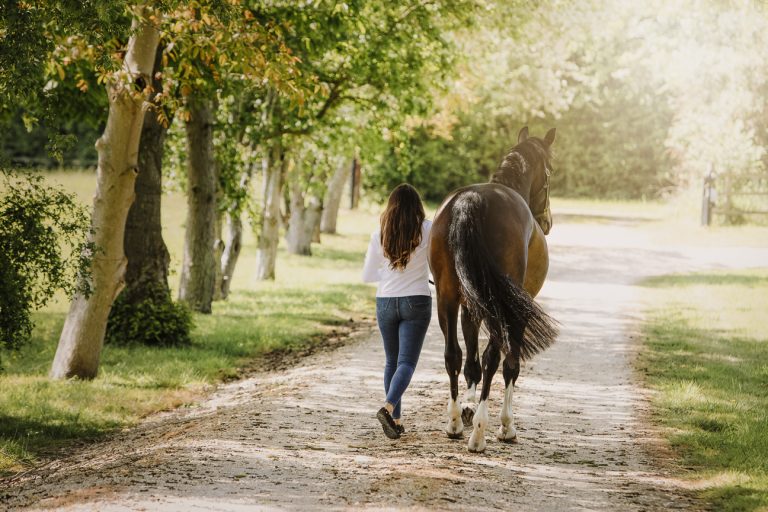 Equestrian walks with her horse down a lane in Berkshire