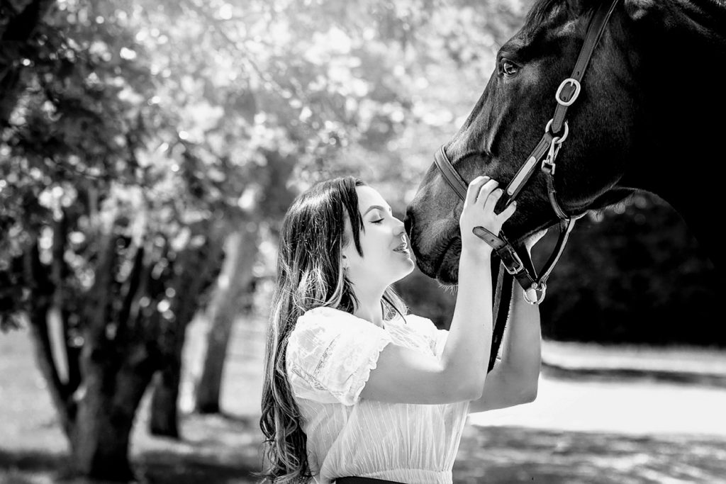 Black and white photograph of woman equestrian kissing her horse in Buckinghamshire